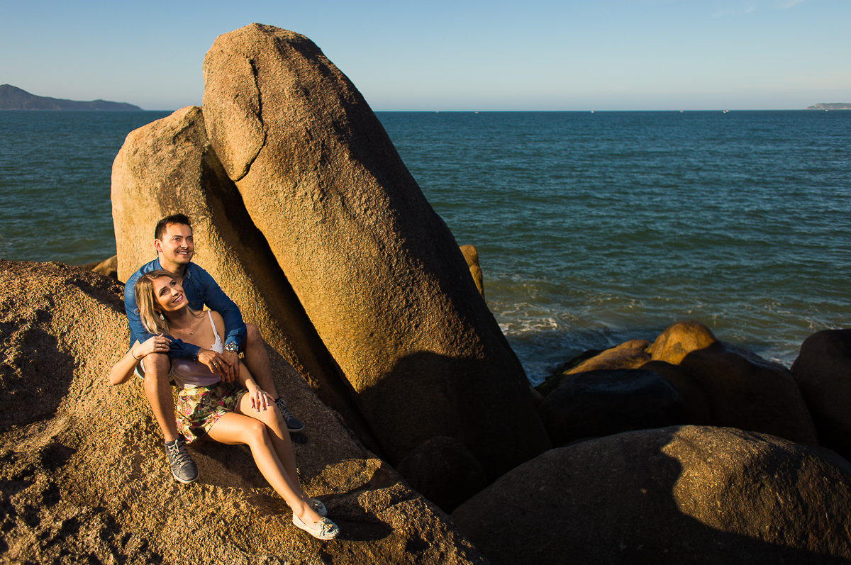 foto de casal em pedras em uma praia em santa catarina