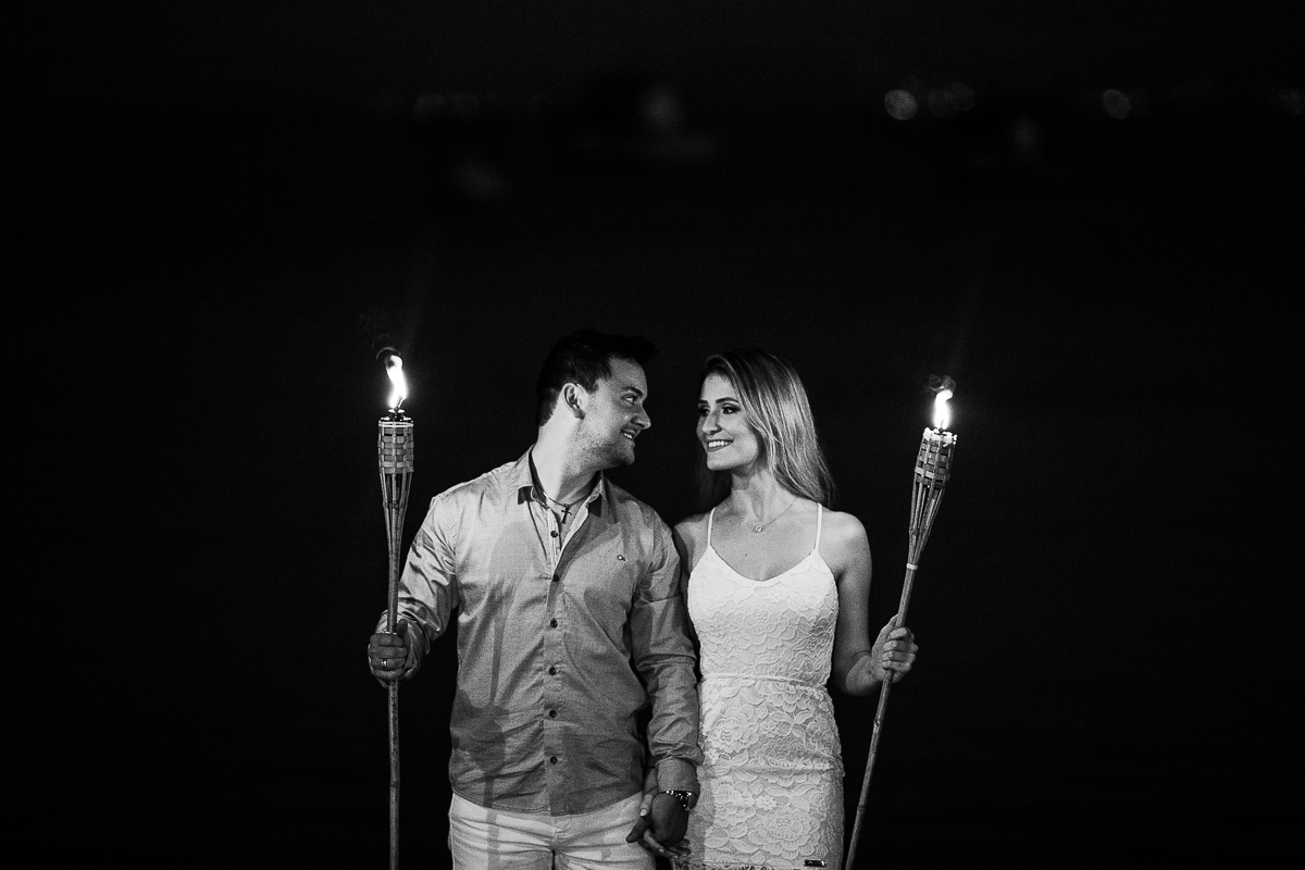 casal se olhando segurando tochas de fogo