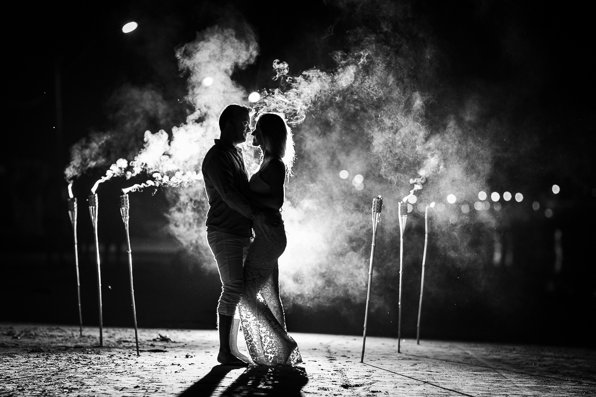 casal se abraçando com tochas de fogo e muita fumaça