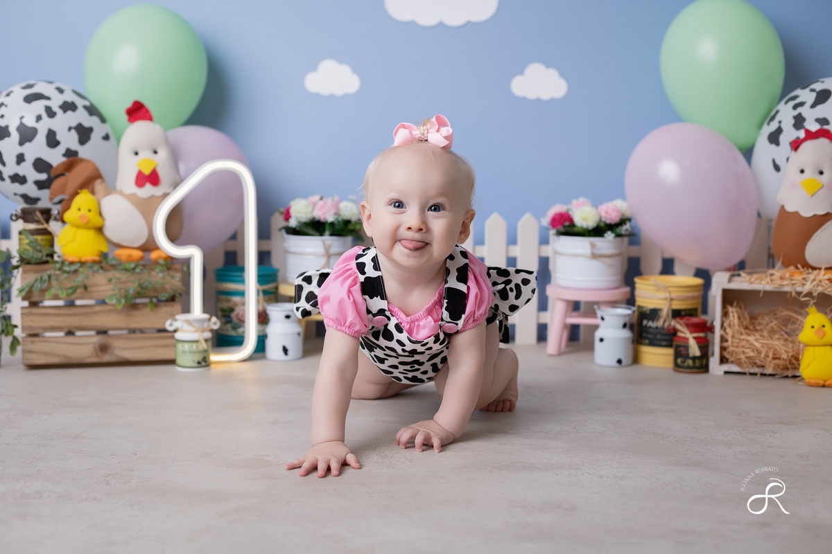 Ensaio smash de 1 ano com bexigas coloridas e tema fazendinha para comemorar seu primeiro aniversário.