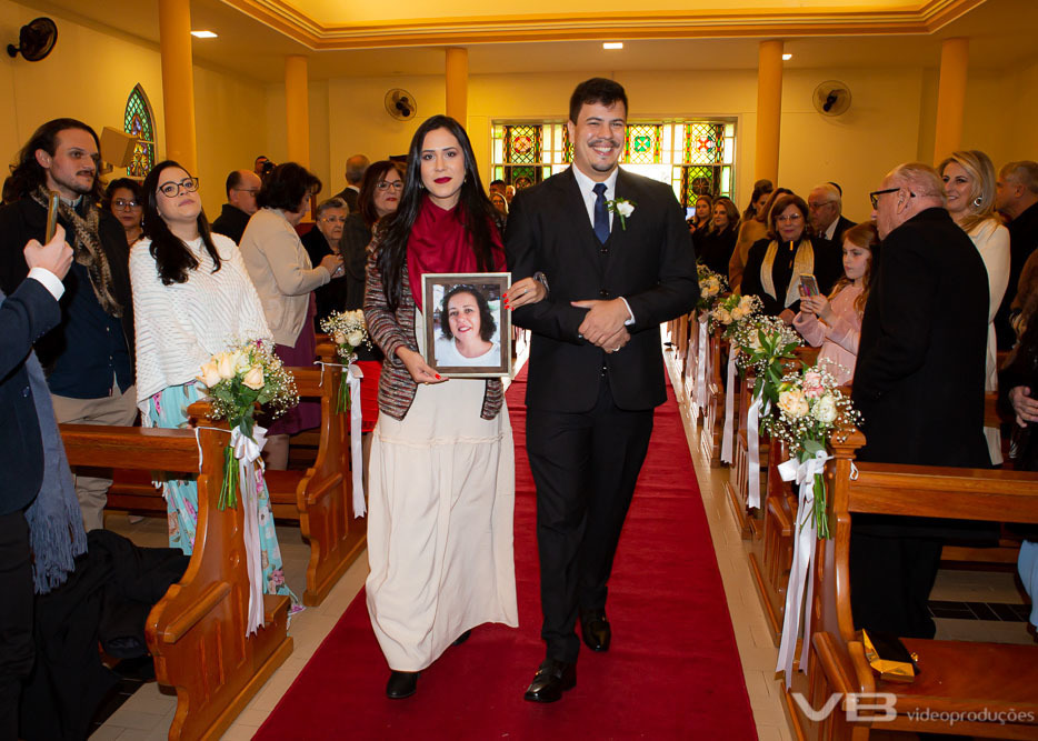 Noivo entrando na igreja com foto da mãe