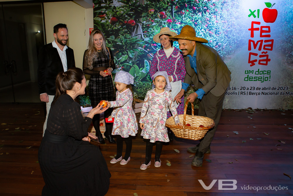 Lançamento da XI Femaçã em Veranópolis, família de agricultores entregando maçãs aos convidados