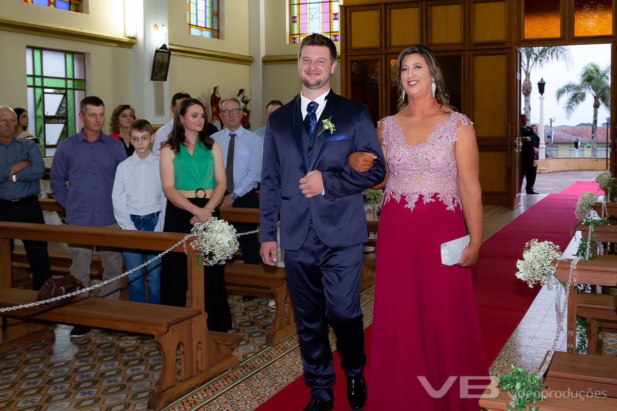 Noivo entrando na igreja acompanhado pela mãe