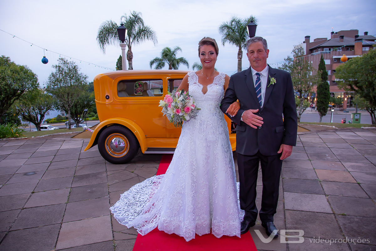 Noiva com o pai em frente a igreja