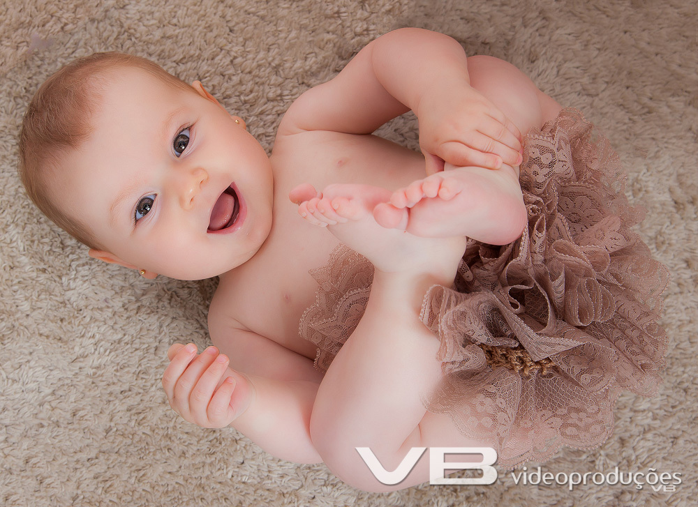 Bebê linda segurando os pés acompanhamento fotográfico do bebê