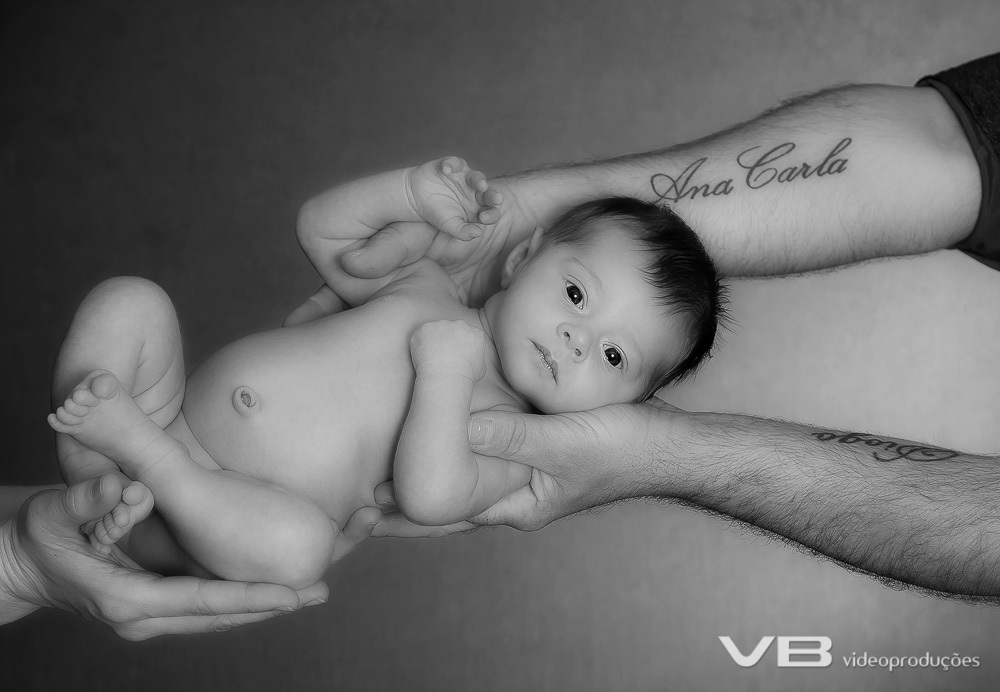 Nenêm peladinho com os pais segurando