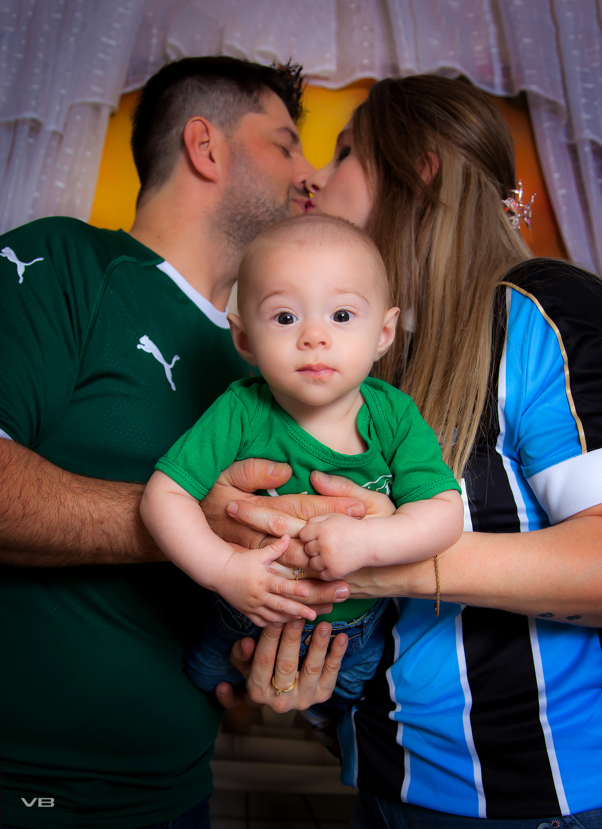 Bebê com pais, camisa de times de futebol