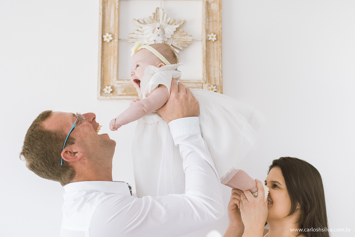 pai, mãe e filhinha se divertindo e atras o quadro do divino espirito santo