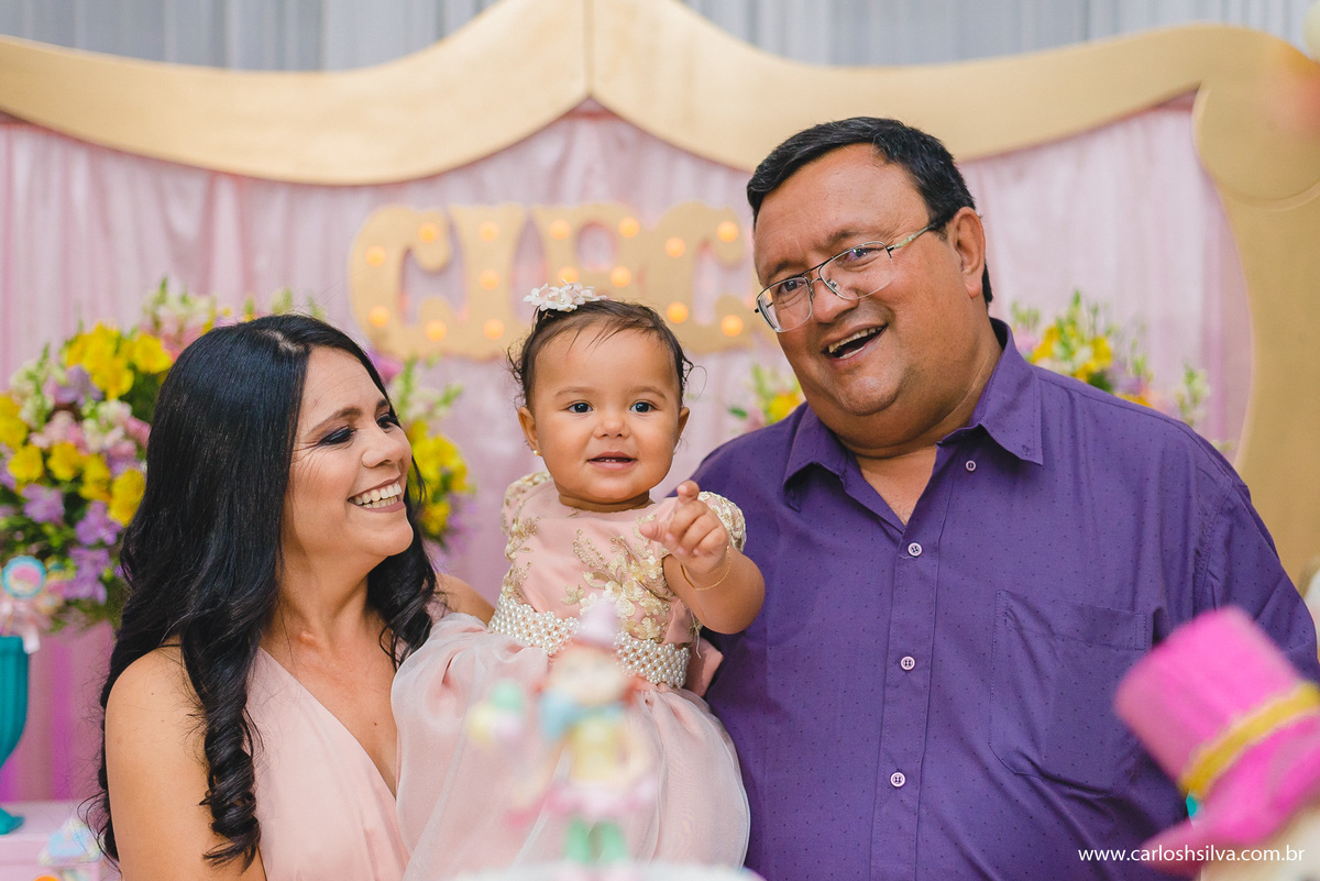 vovô e vovó tirando foto na mesa de doces com a netinha