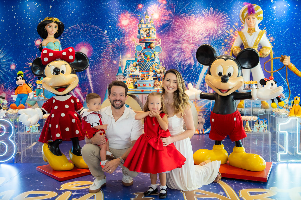 pais e filhos ajoelhados em frente a decoração 