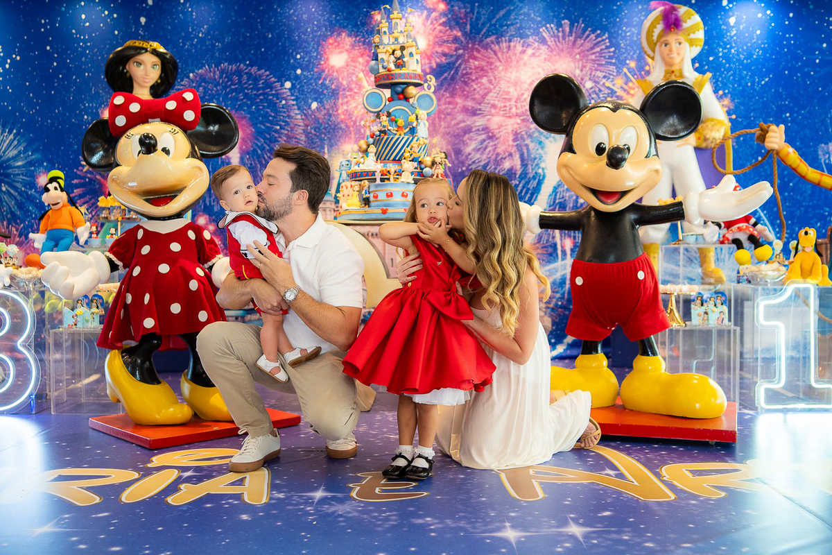 pai beijando a bochecha do filho e mãe beijando a bochecha da irmã 