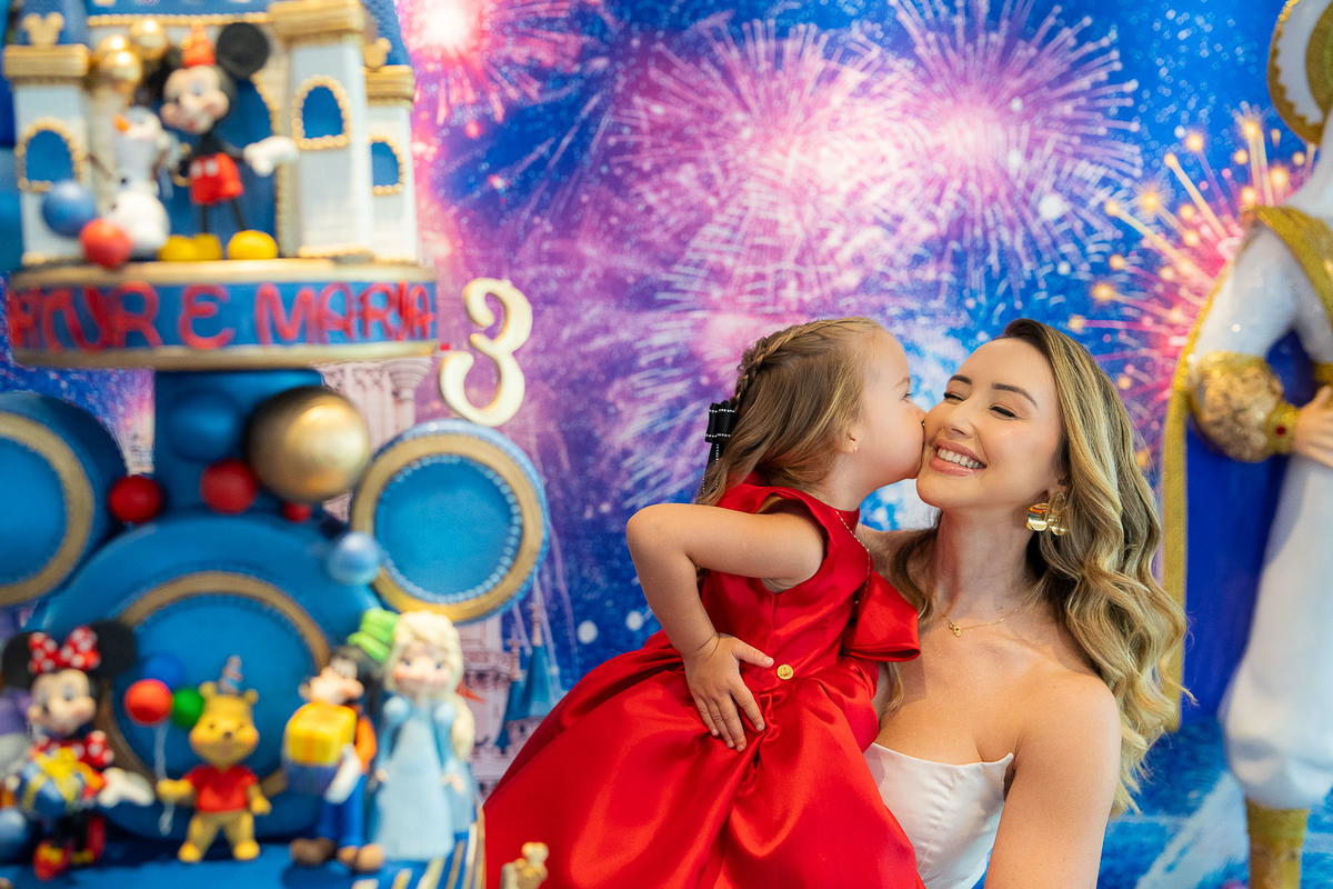 mãe sorrindo com a filha no colo