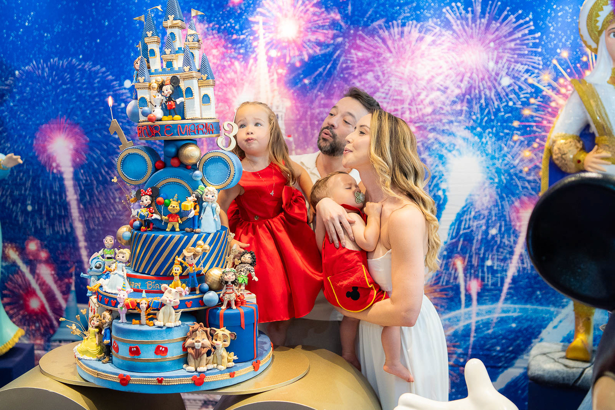 pais e filhos soprando a vela do bolo