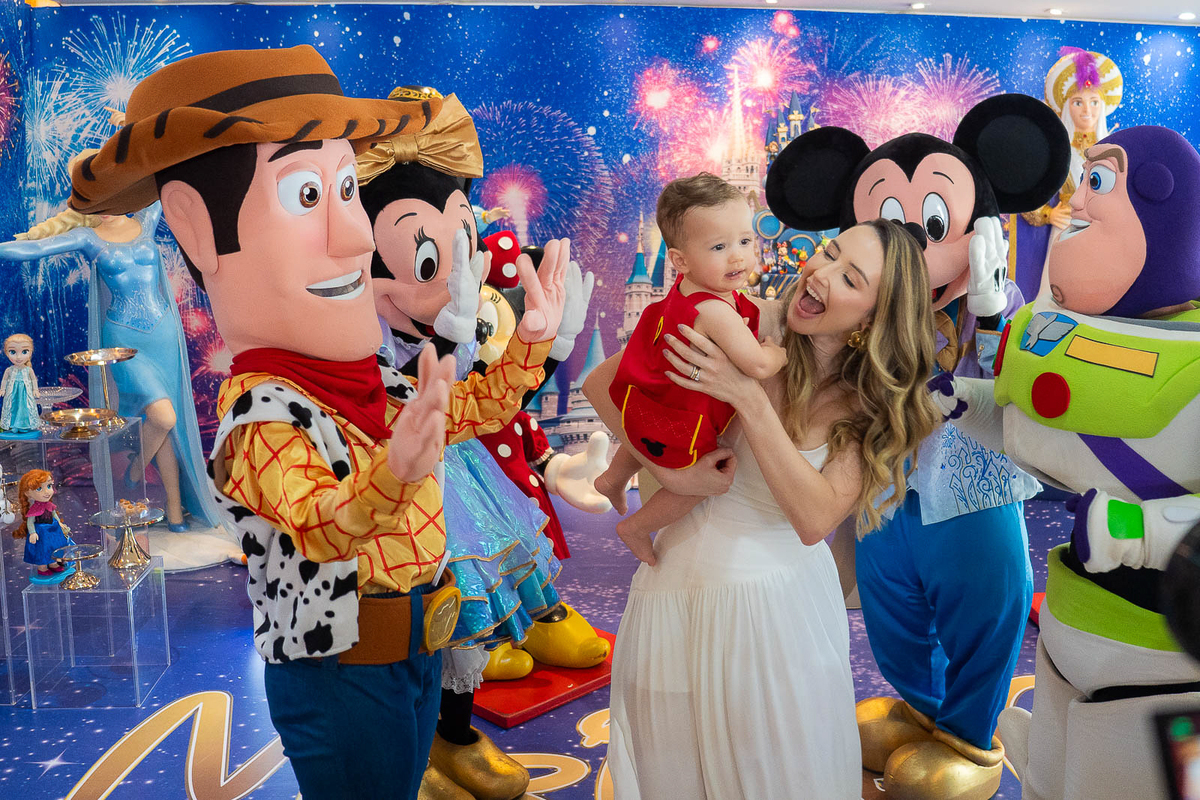 bebê no colo da mãe rindo com os personagens 