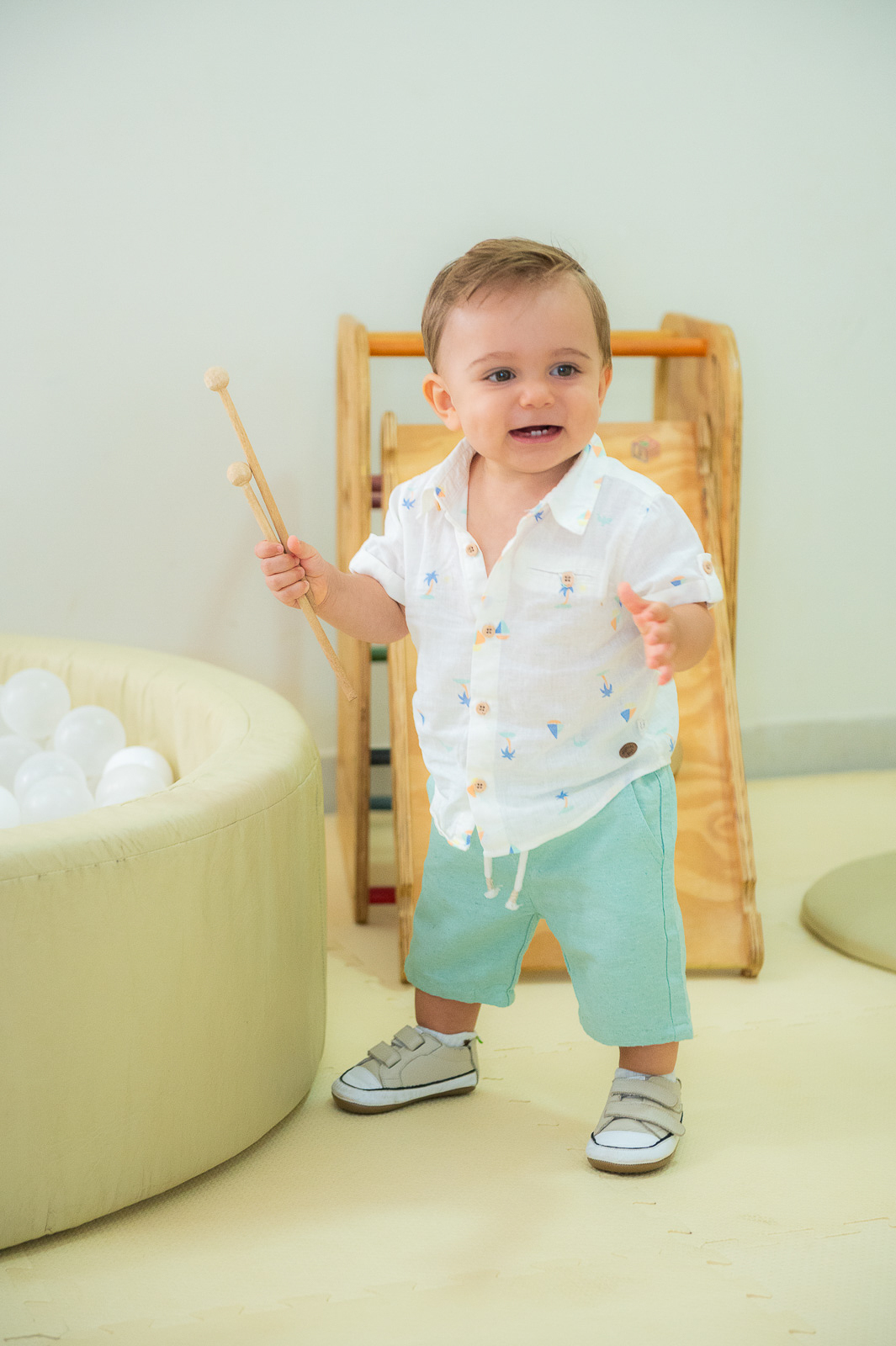 menino sorrindo com brinquedo na mão