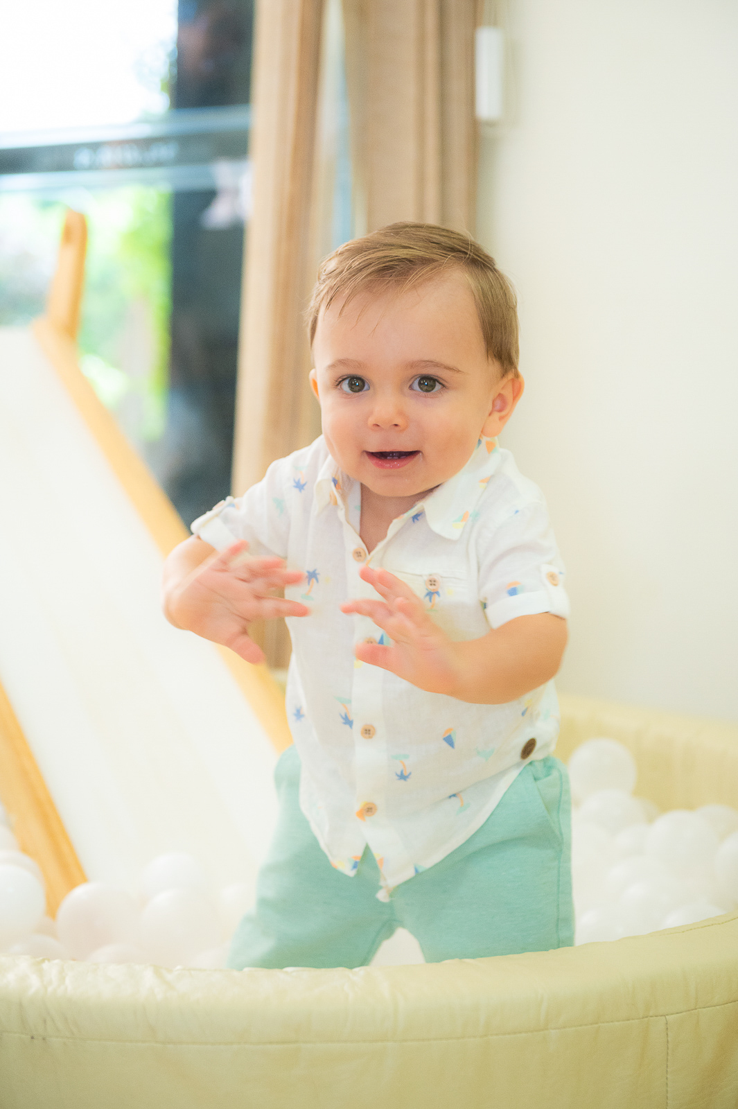 bebê olhando pra câmera com as mãos na frente