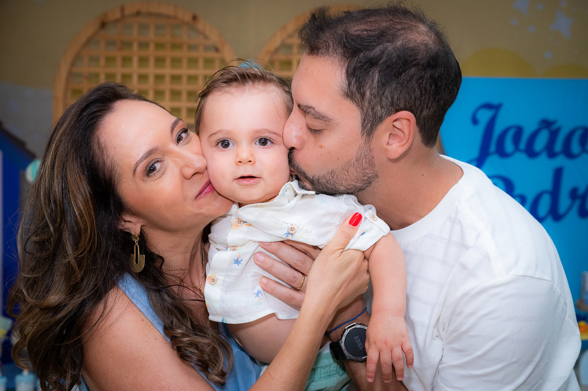 pais carinhosos dando beijo na bochecha do filho 