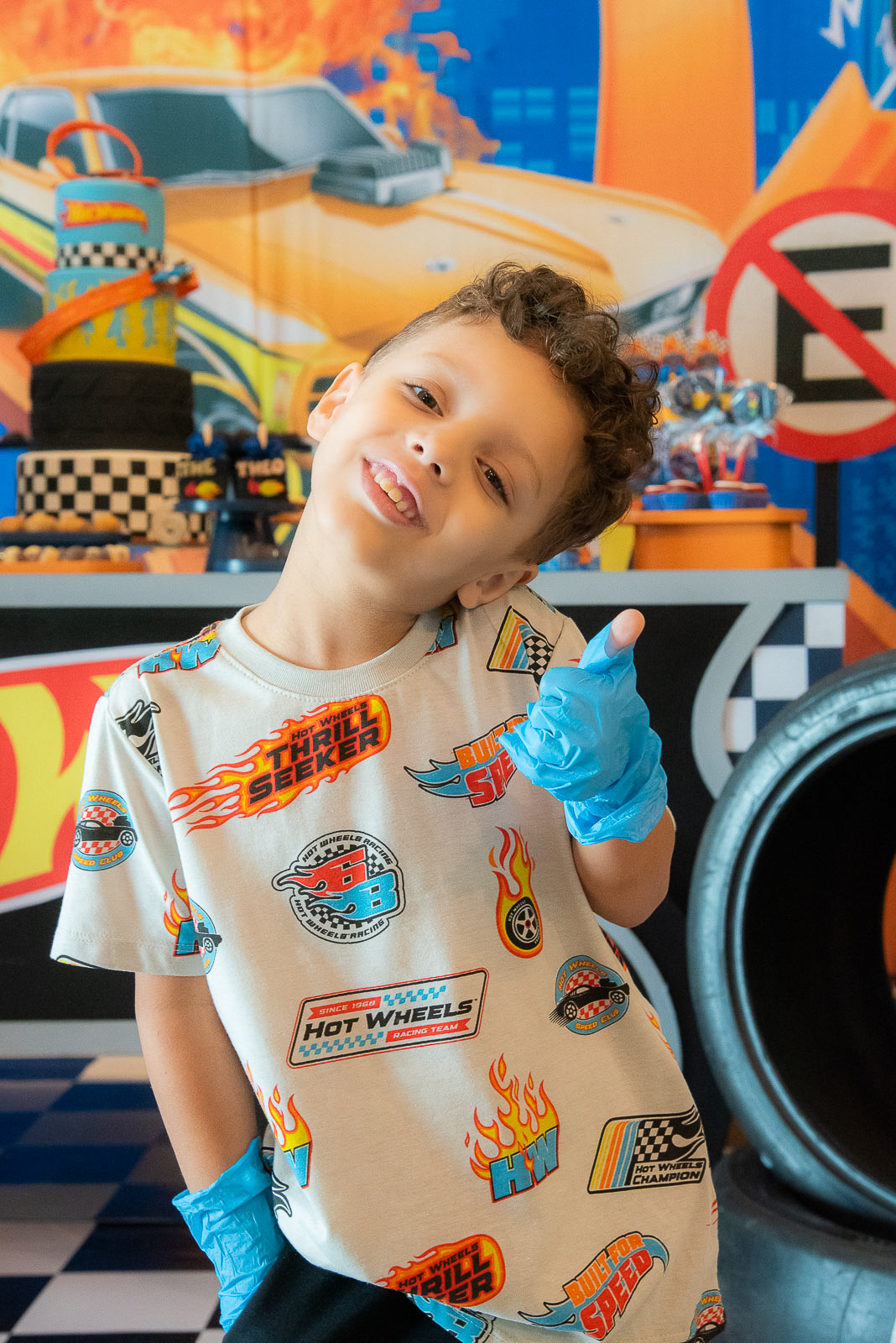 Menino sorrindo e apontando pra câmera 