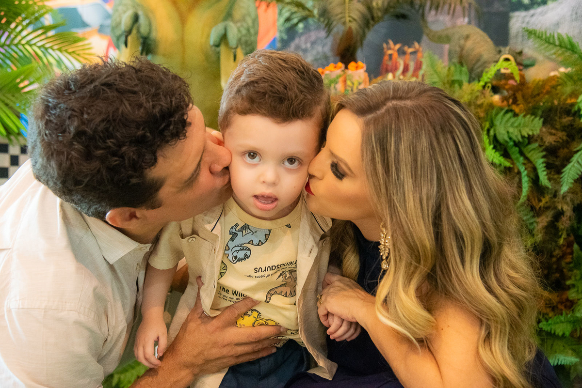 pais beijando o filho na bochecha 