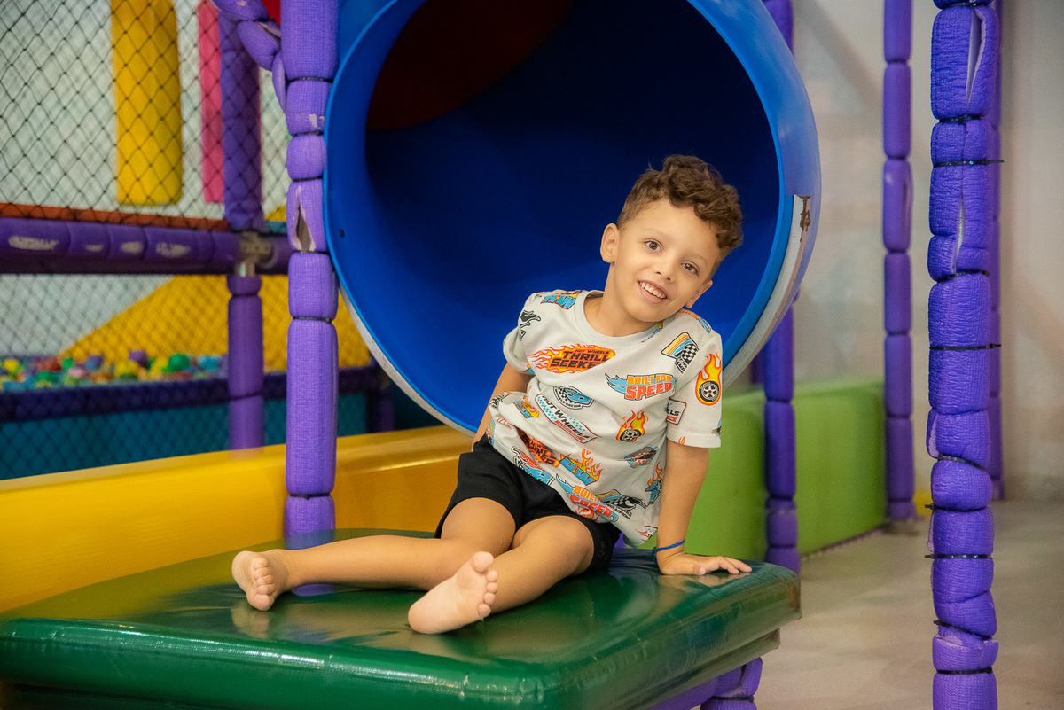 filho sorrindo perto do tobogã 