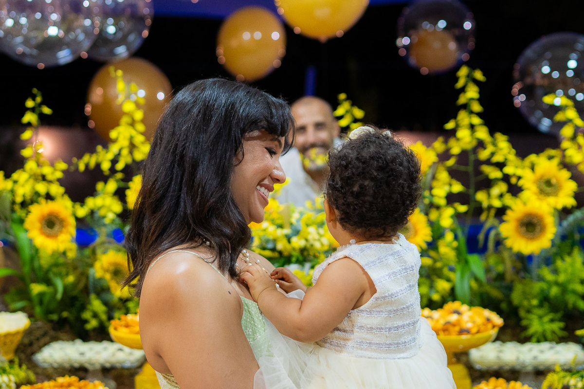 papai fazendo gracinha para a filha no coo da mae