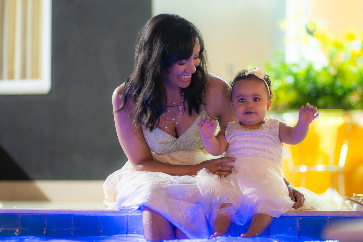mae e filha brincando a beira da piscina