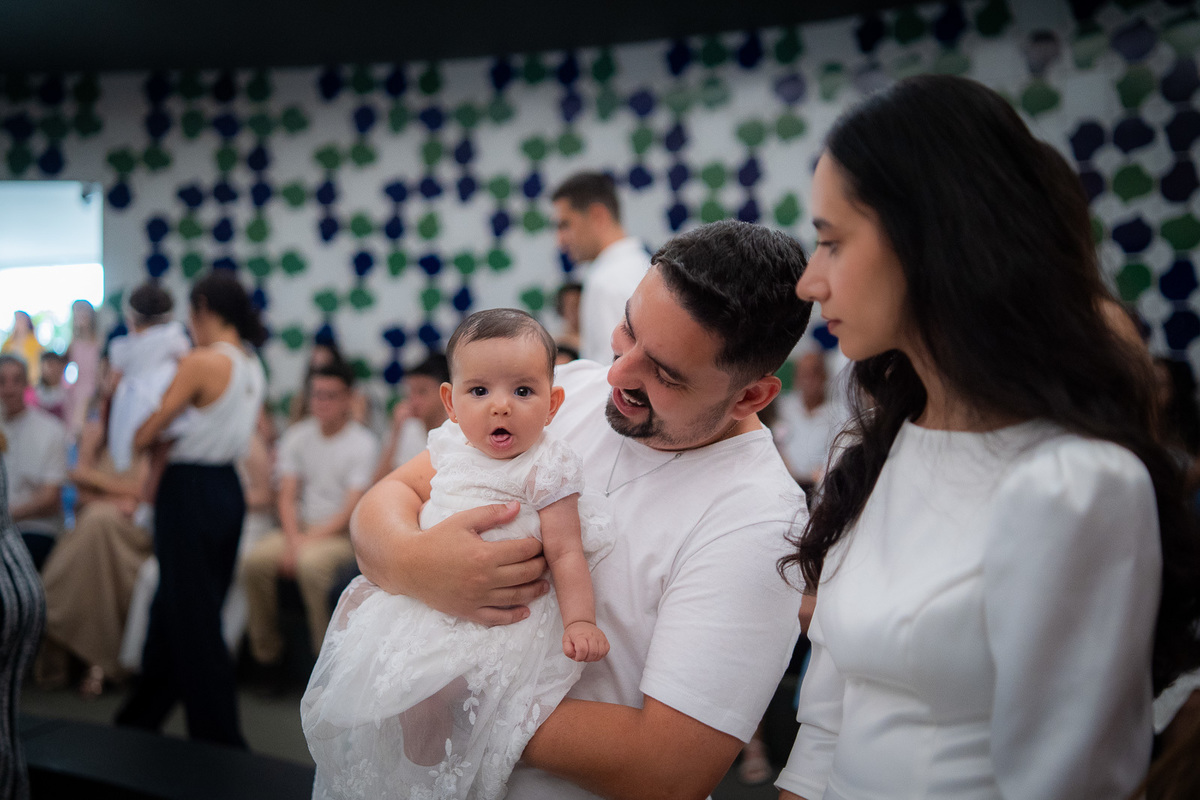 pai segurando o bebê no colo e sorrindo 