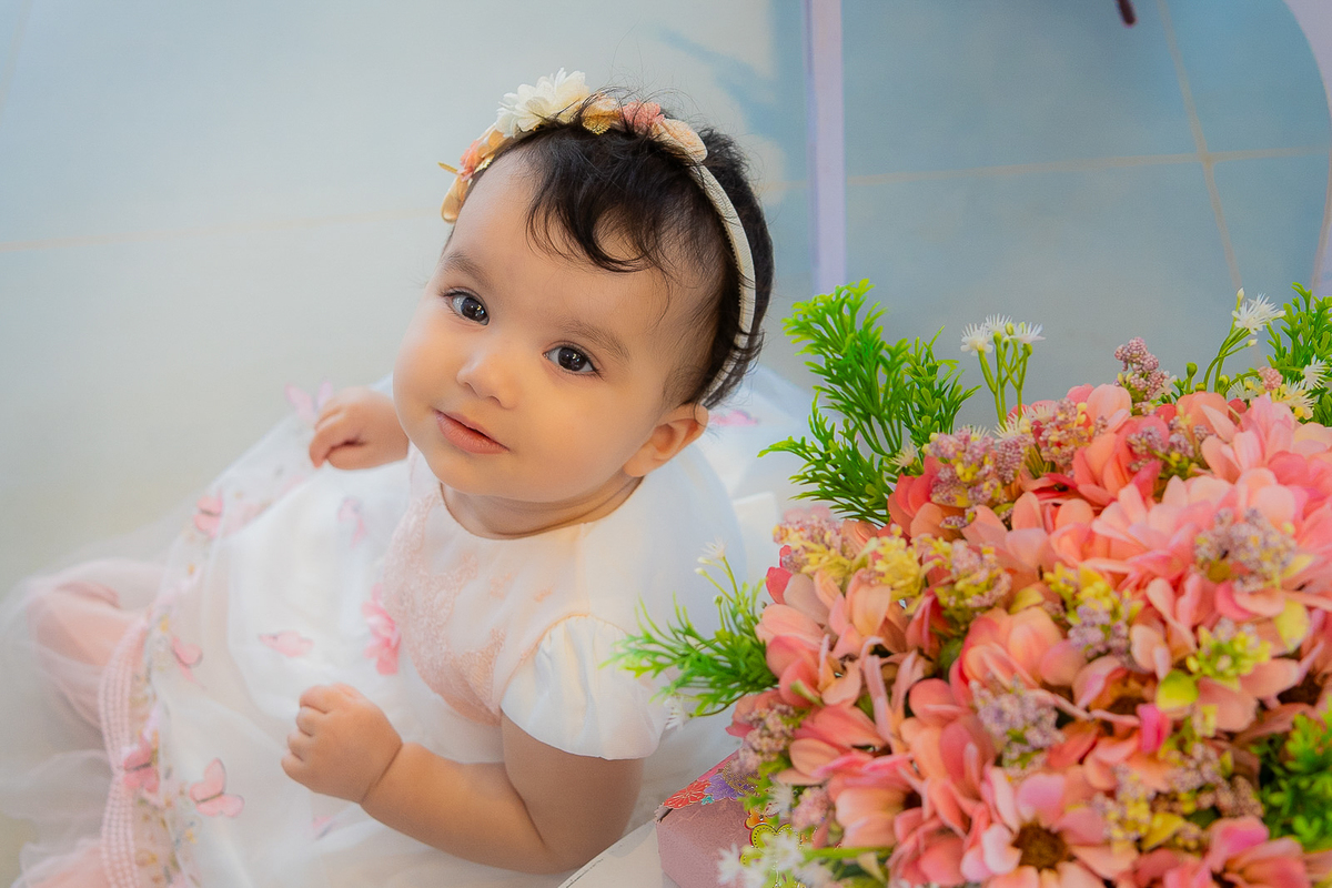 Bebê ao lado das flores