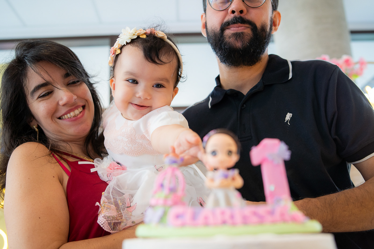 bebê sorrindo para o bolo