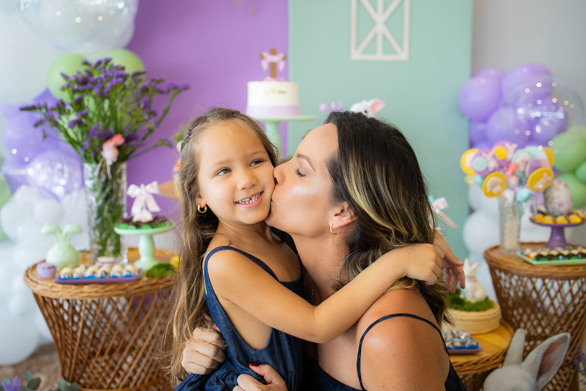 mãe beijando a bochecha da filha