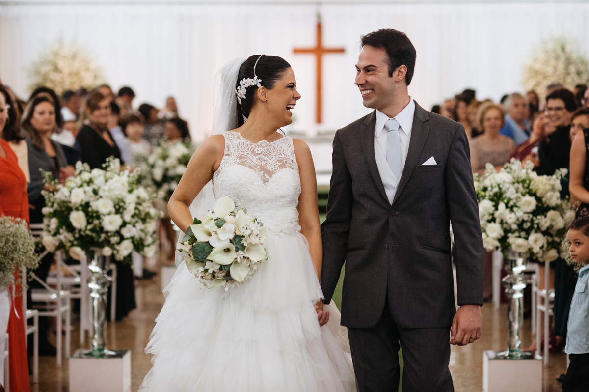 Felizes os noivos deixam a cerimonia