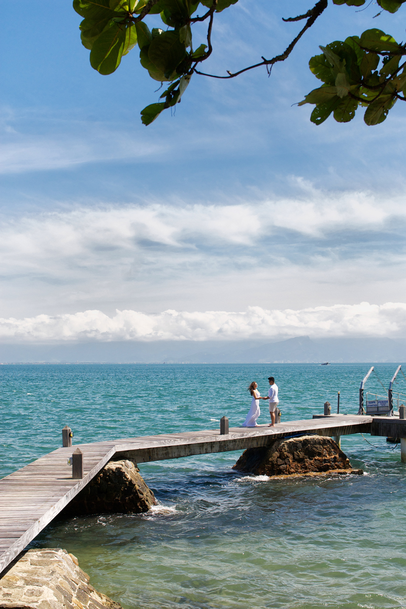 noivos caminham sobre o pier