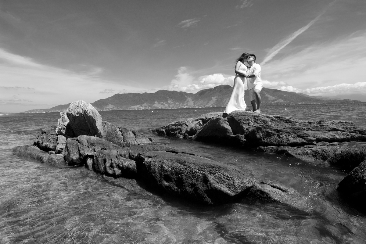 noivos se beijam sobre as rochas