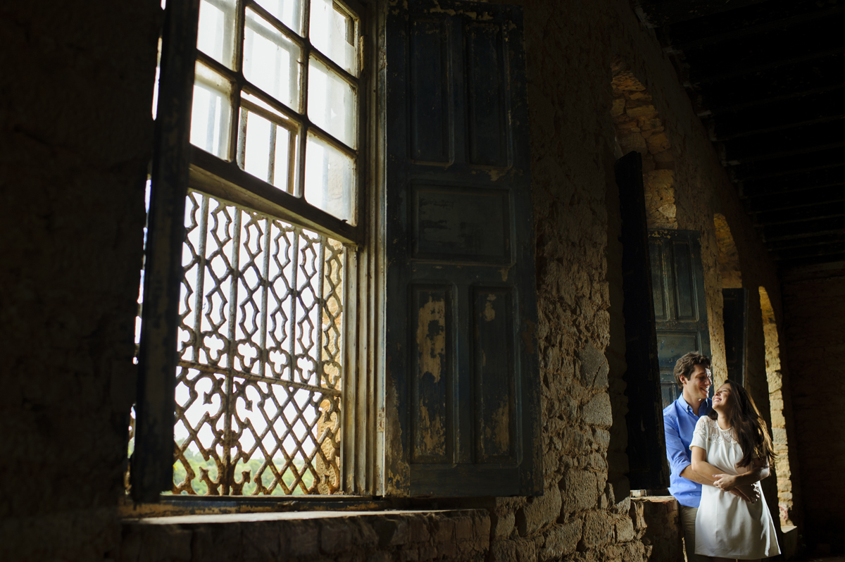 Casal namora frente a janela antiga