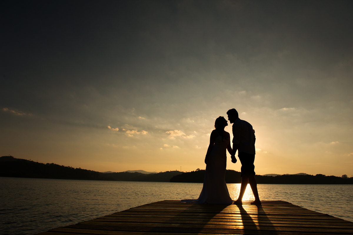 silhueta de noivos na represa