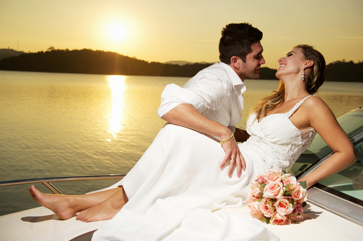 noivos namoram na lancha sob por do sol