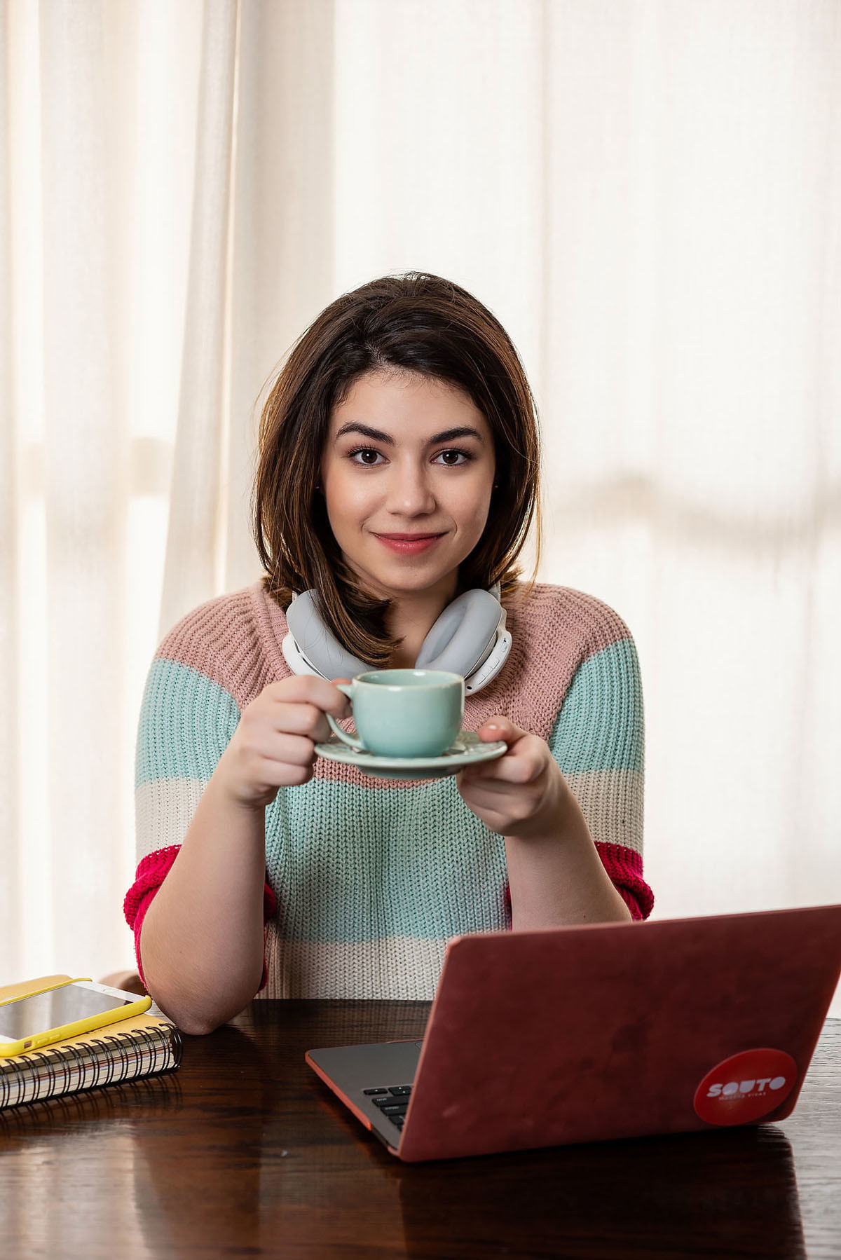 garota com fone toma café