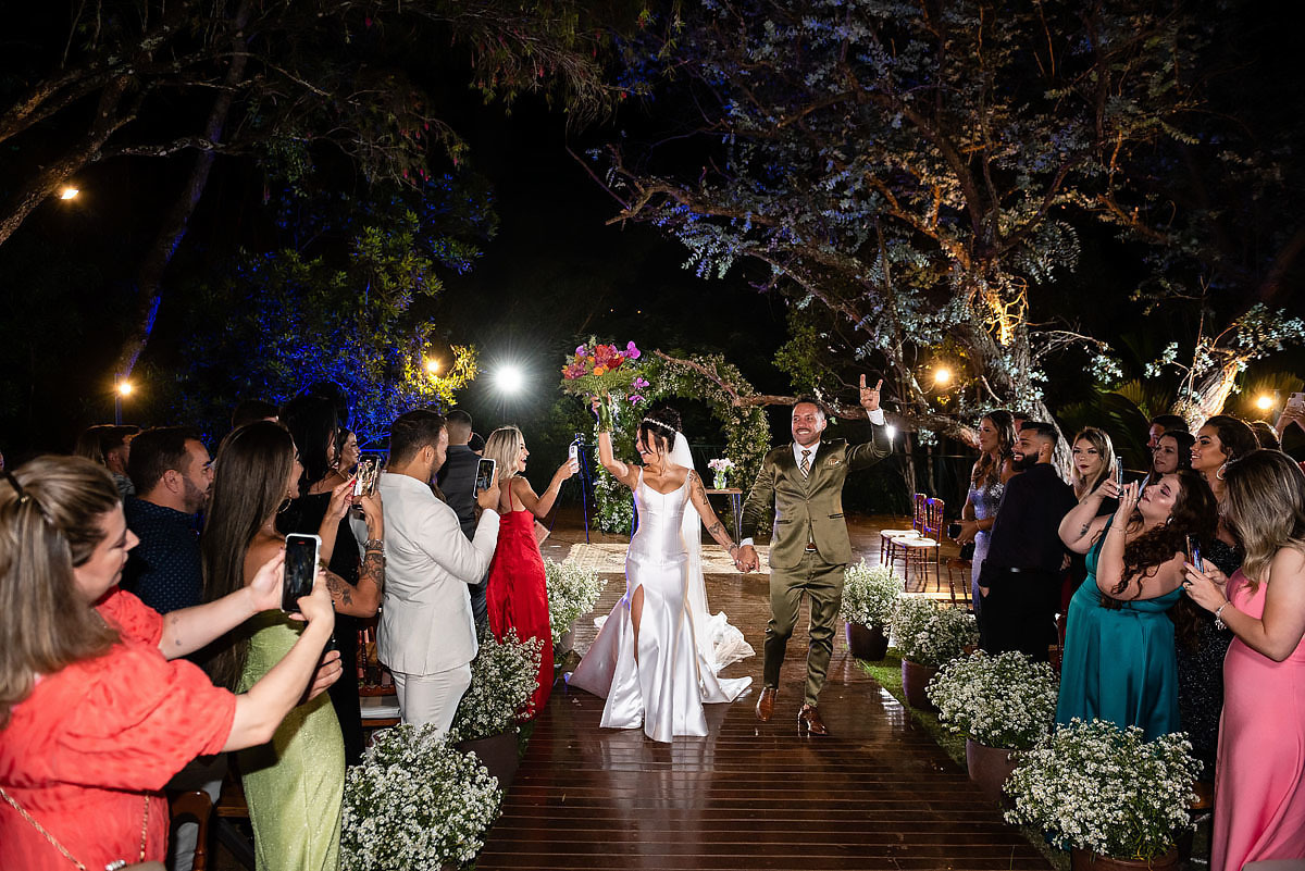 Casamento de noite no alto das palmeiras, saída da noiva