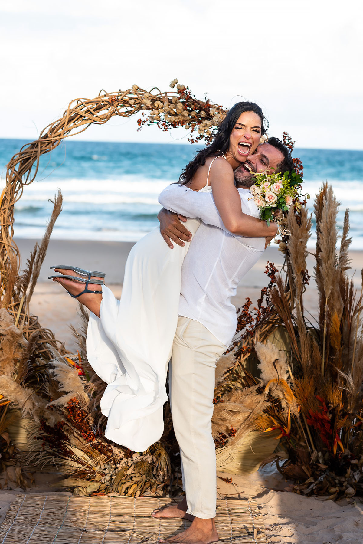 Casamento no final da tarde na praia, casamento na Bahia. noivo levanta a esposa.