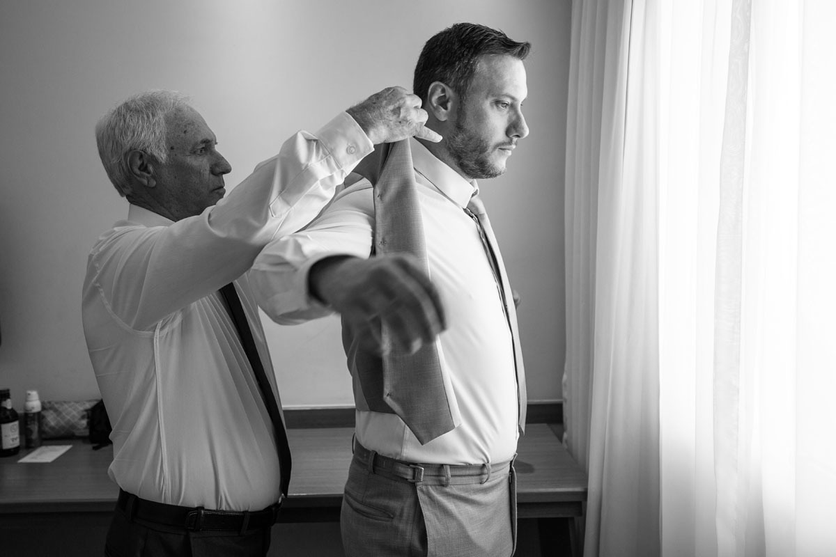 Pai coloca o terno no noivo