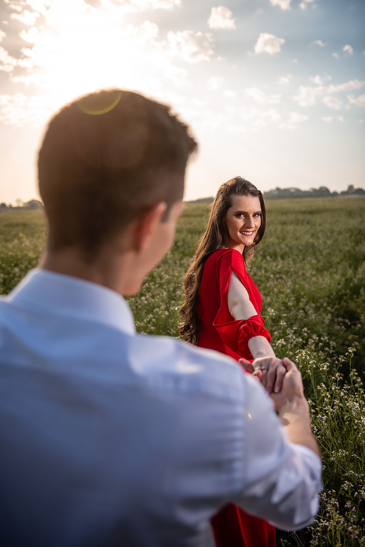 Casal troca olhares em campo florido