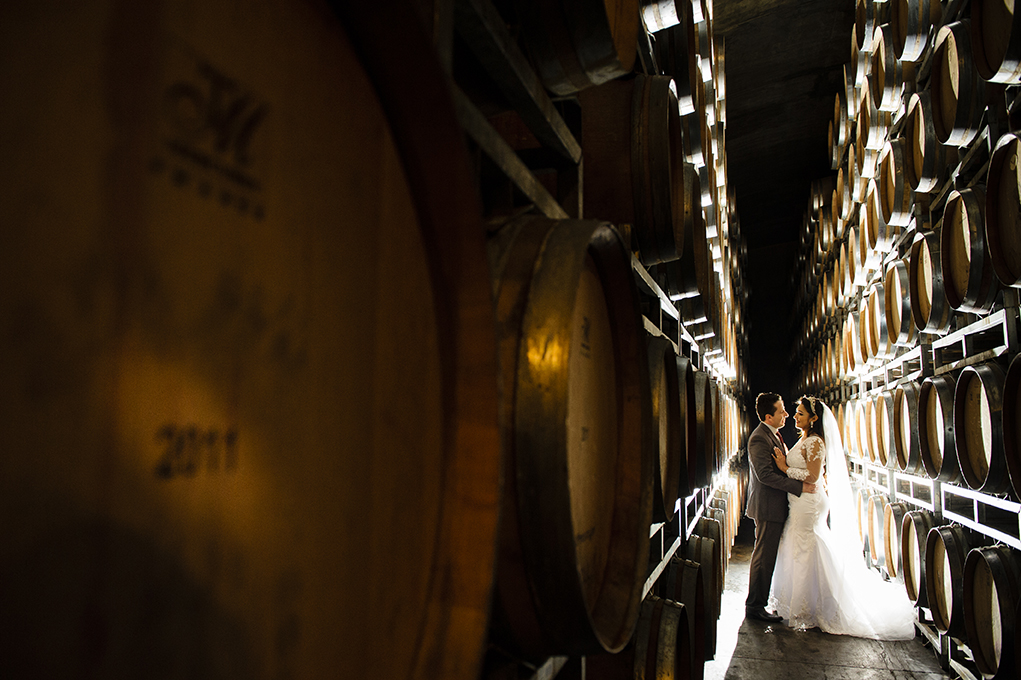 noivos se beijam na adega de vinhos