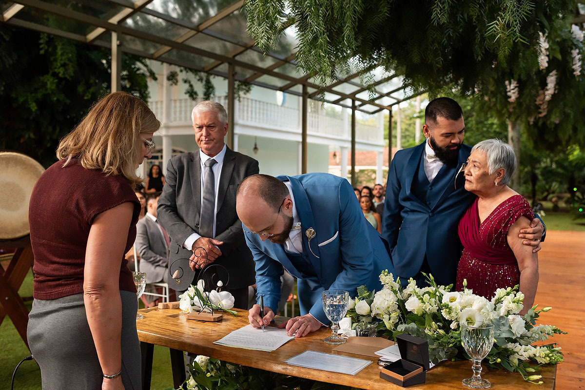 Casamento de meninos, fazenda Santa Isabel, casamento no campo, casamento com chuva, noivos assinando documento.