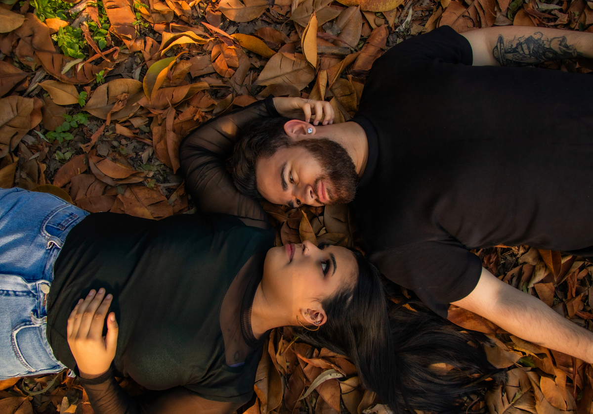 Casal deitado nas folhas de outono