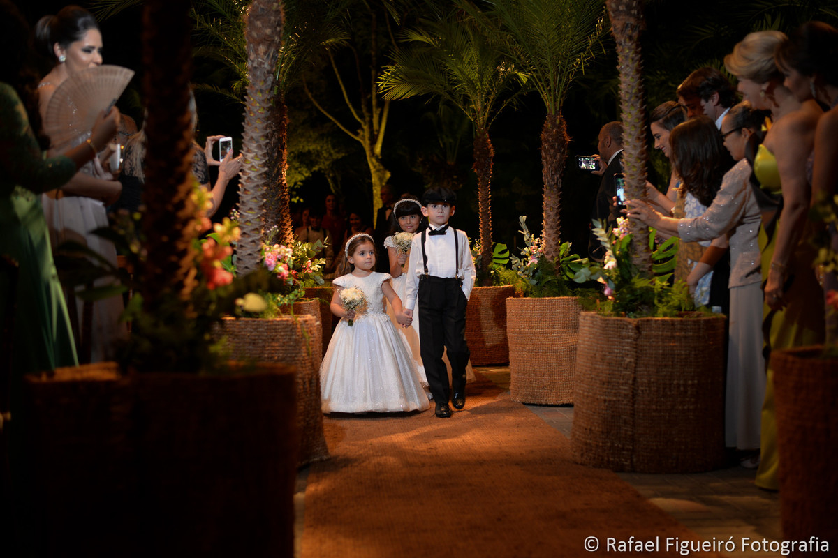 Pajens lindos entrando no casamento em corredor de palmeiras fotografado por rafael figueiro
