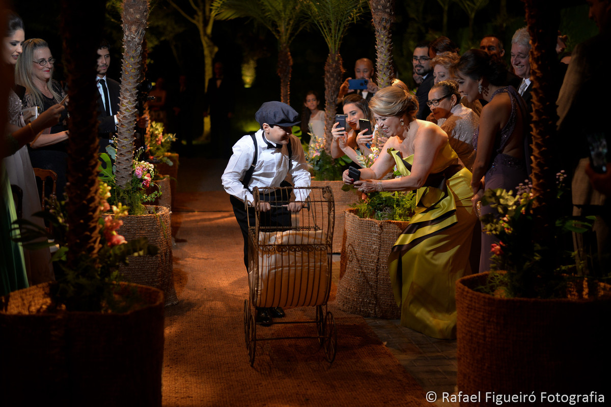 Pajens lindos entrando no casamento em corredor de palmeiras fotografado por rafael figueiro
