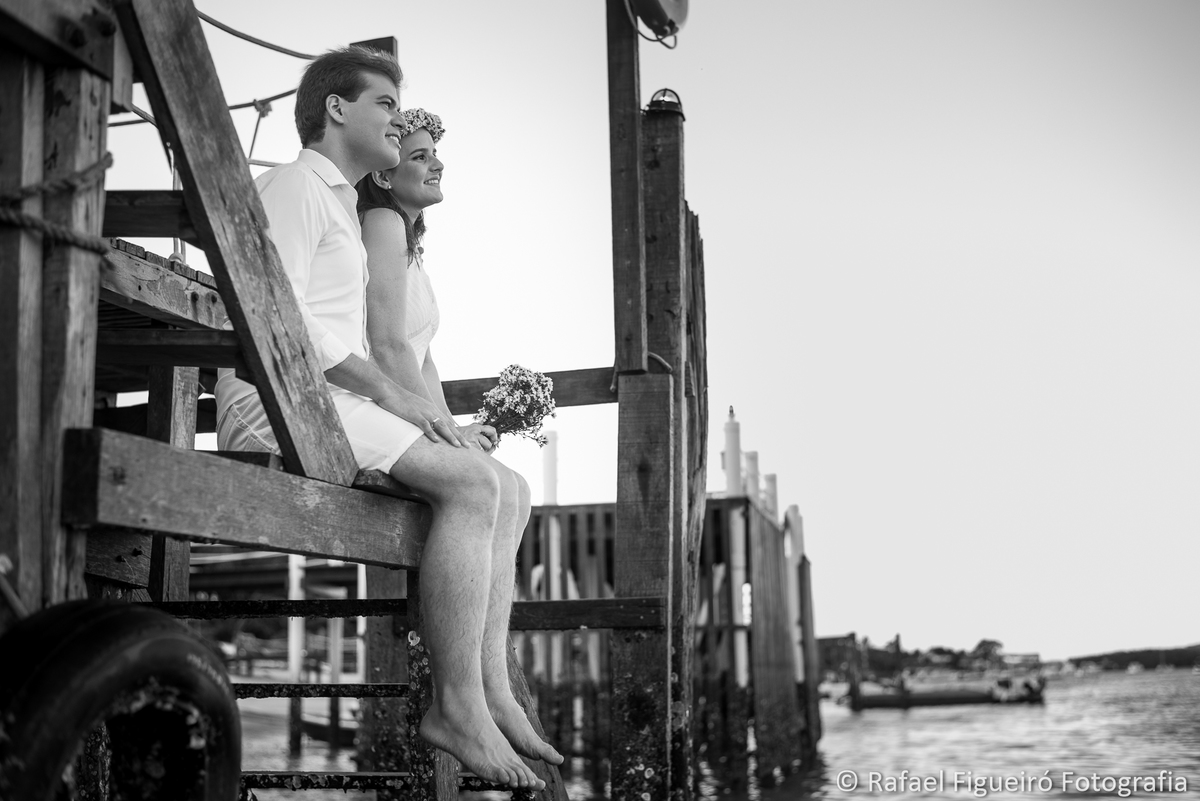 casal sentado olhando horizonte rio timbo pier de madeira