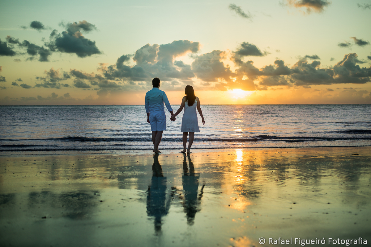 casal de maos dadas olhando mar sol nascendo praia maria farinha pe