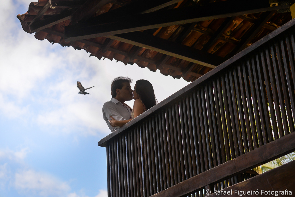 casal namorando varanda madeira pomba voando céu azul nuvens