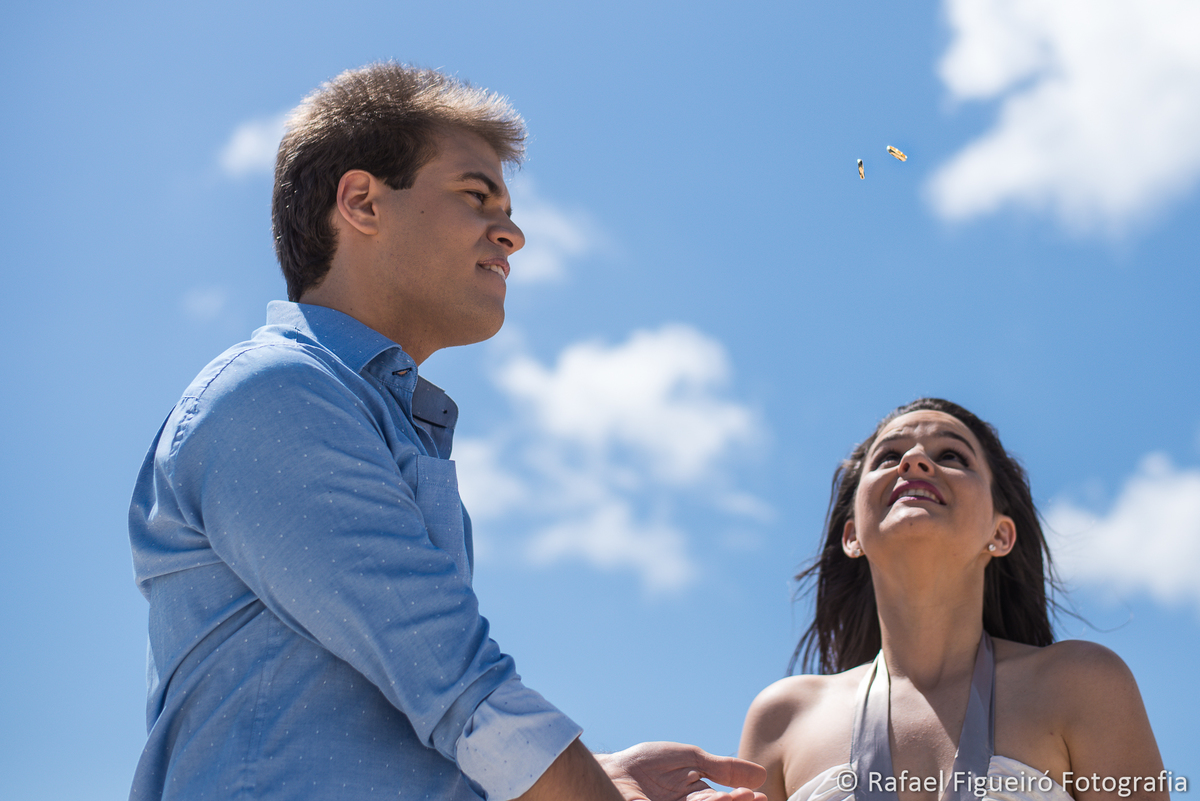 alianças voando noiva assustada noivo concentrado nuvens ceu azul